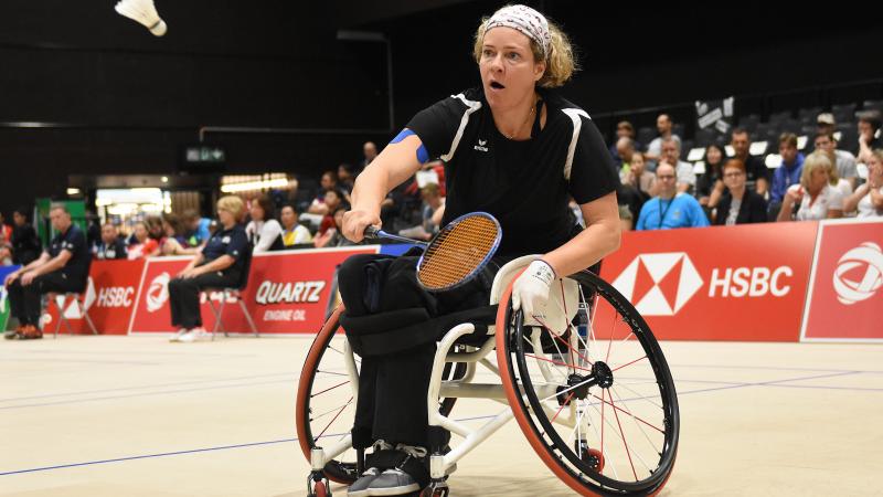 A woman in a wheelchair playing badminton 