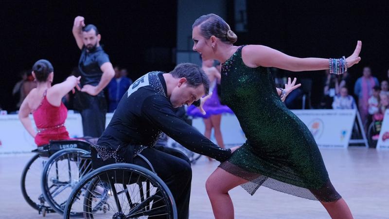Man in wheelchair dancing with standing partner