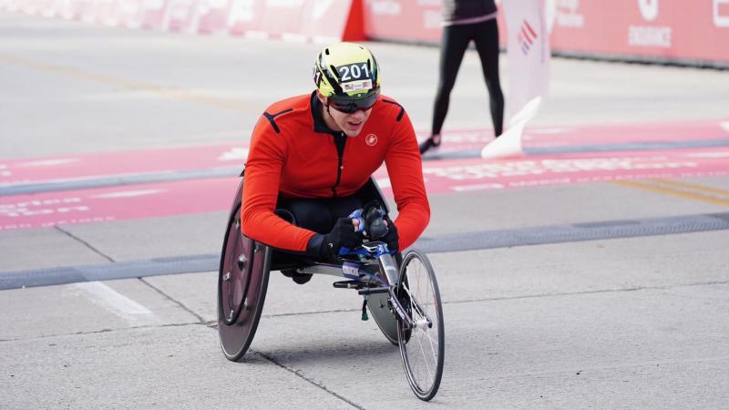 A man in a wheelchair race crossing the finish line of the Chicago Marathon