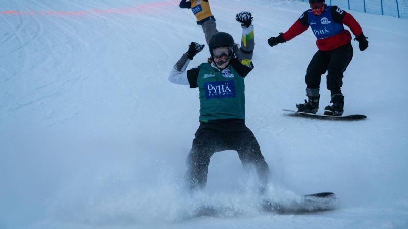 Male snowboarder celebrates after crossing finishline