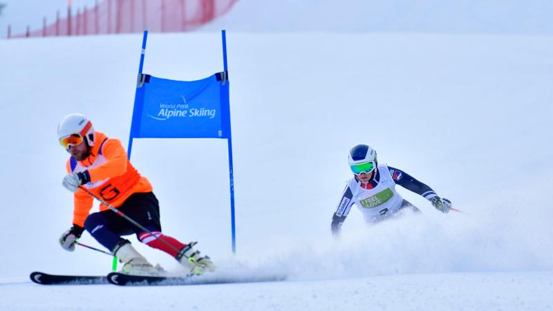 A female Para alpine skier behind her guide