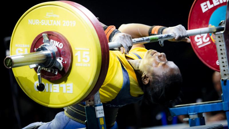 Female powerlifter holds onto the bar preparing for her lift