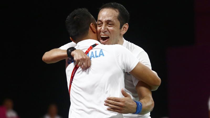 Raul Anguiano embraces his coach after winning badminton gold at Lima 2019