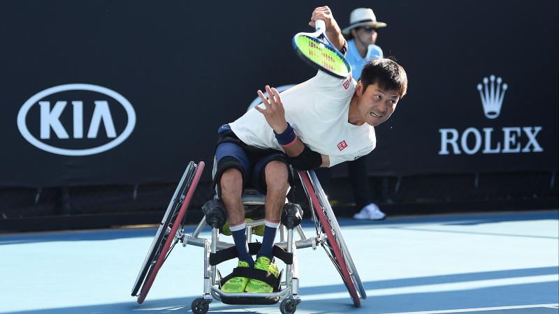 Japanese man in wheelchair hits a return shot in tennis