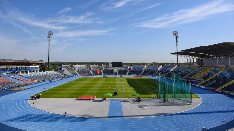 A stadium with a blue athletics track and field 