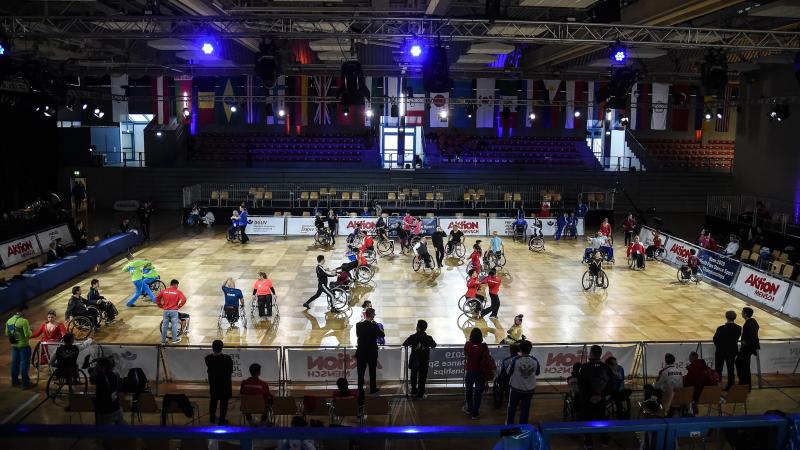 A group of dancers in wheelchairs on a court with their dancing partners