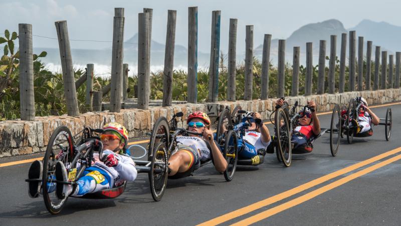 Five female hand cyclist racing in a line