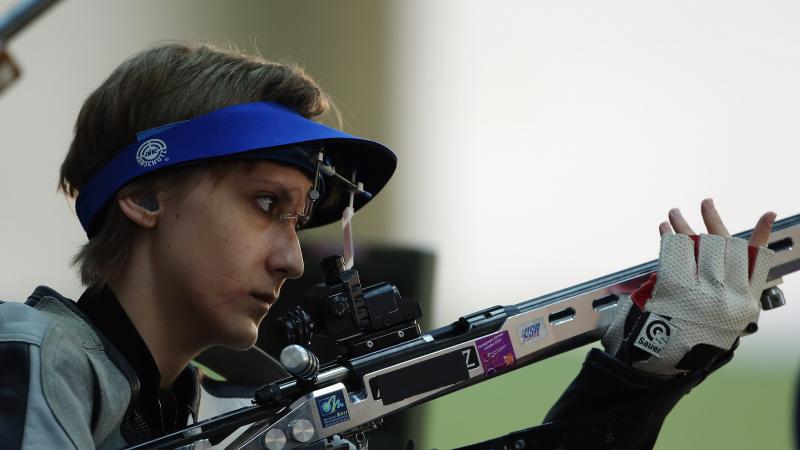 A woman holding a rifle in a shooting Para sport competition