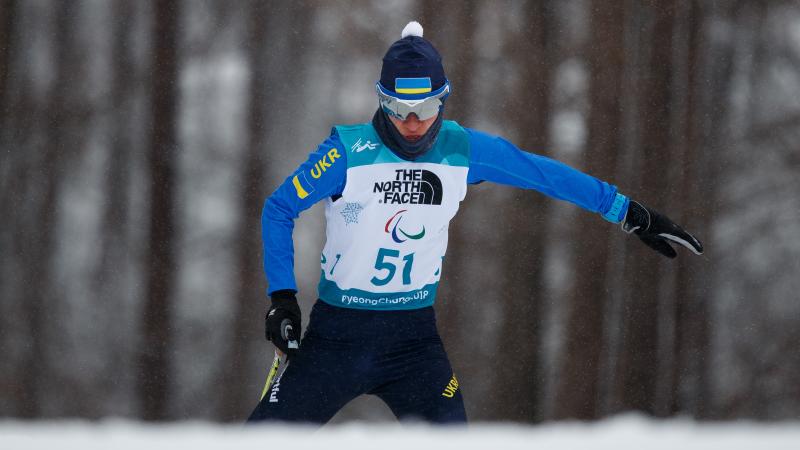 A female standing Para biathlete in the snow