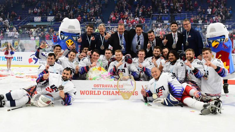 A group of men on an ice rink celebrating with their medals