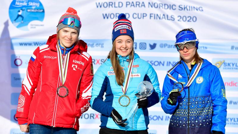 Three women in a podium with their medals