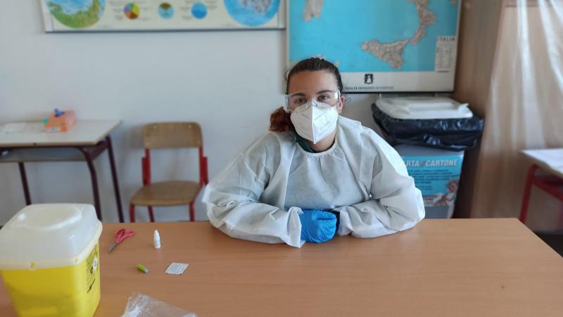 Italian female dressed in protective equipment with face mask, goggles and gloves