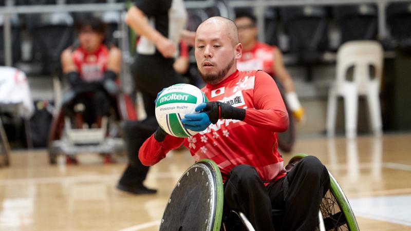 Male Japanese wheelchair rugby player holding a ball