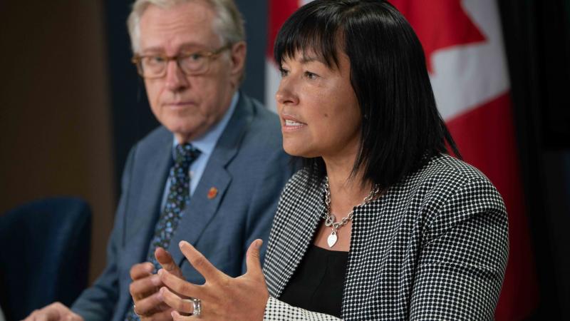 Chantal Petitclerc speaks with Canadian flag behind