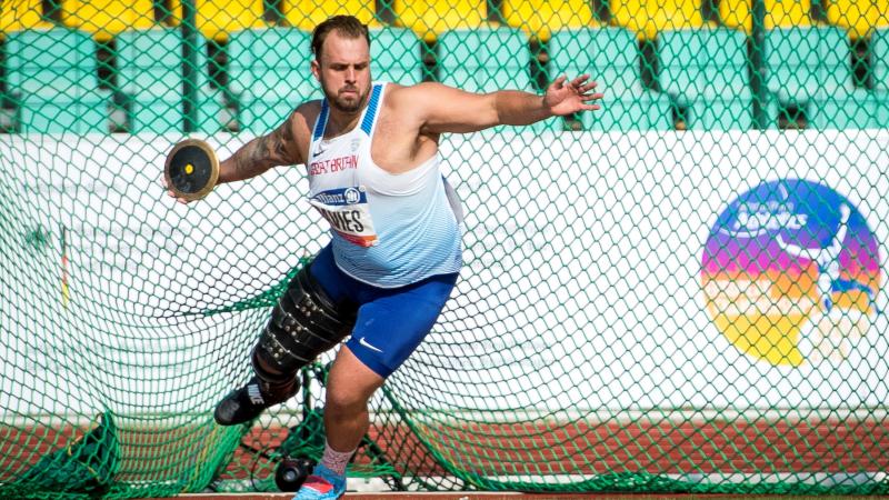 A man with a prosthetic leg competing in shot put