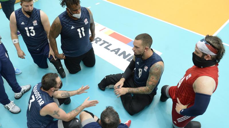 US sitting volleyball team chatting on the floor