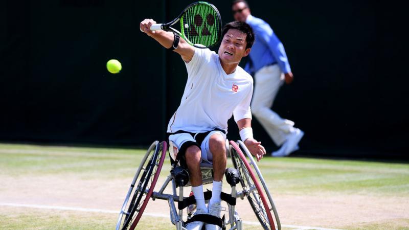 Japanese male wheelchair tennis player does backhand return