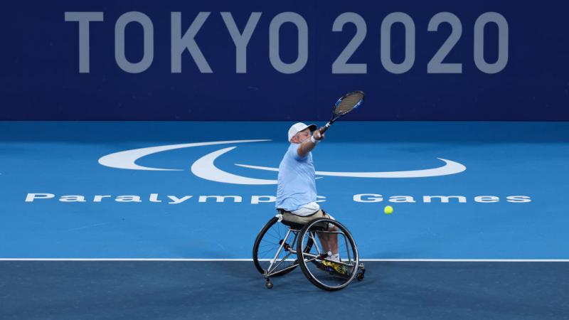 Steven Olsson plays a shot in front of Tokyo 2020 logo