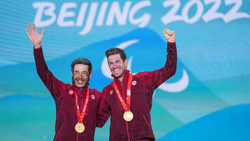 Brian Brian McKeever and Guide Graham Kennedy smile and wave after receiving their gold medals at Beijing 2022
