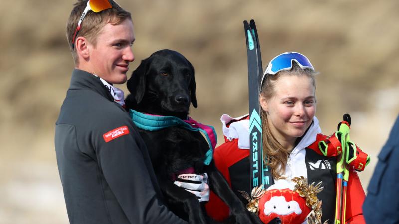 Gold medallist Carina Edlinger of Austria looks on with her guide dog Riley following the Women's Sprint Free Technique Vision Impaired Final flower ceremony in the Beijing 2022 Paralympic Winter Games at Zhangjiakou National Biathlon Centre. 