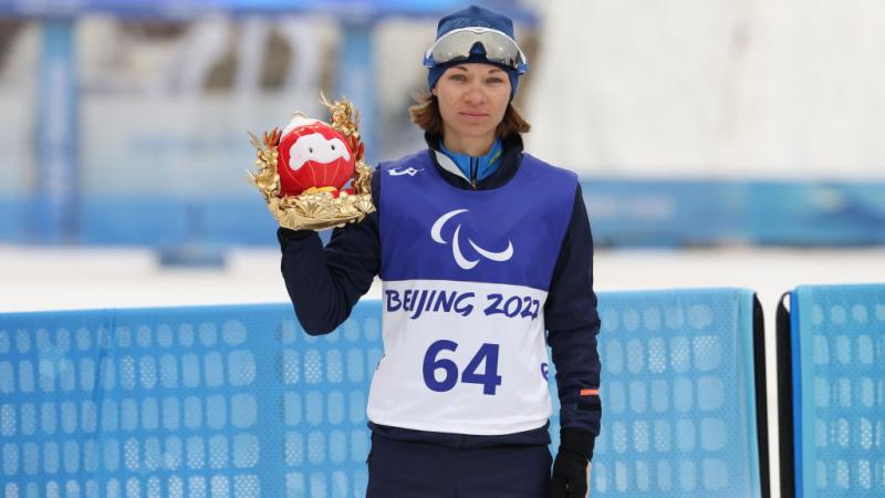 Liudmyla Liashenko of Ukraine poses after winning the Para Biathlon Women's Individual Standing at the Beijing 2022 Winter Paralympics. 