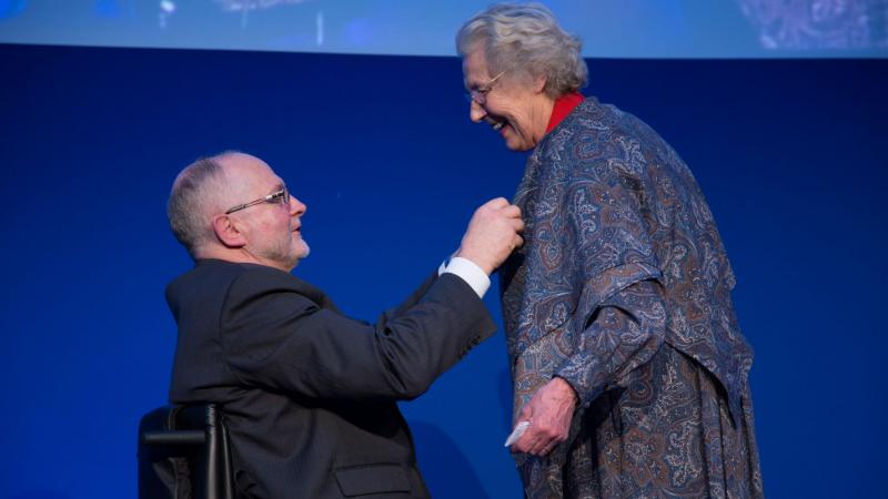 Sir Philip Craven presents the Paralympic Order to a smiling Jonquil Solt.