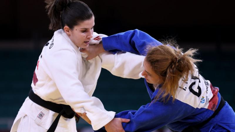 Two female judokas grapple in a competitive bout