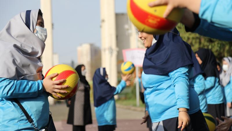 Teenage girls toss a ball as part of National Paralympic Day activities.
