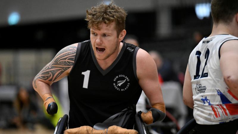 A male athlete wearing a black jersey competes at the 2022 Wheelchair Rugby World Championships