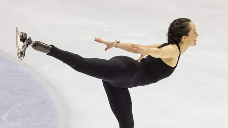 A female athlete with a prosthetic leg skates.