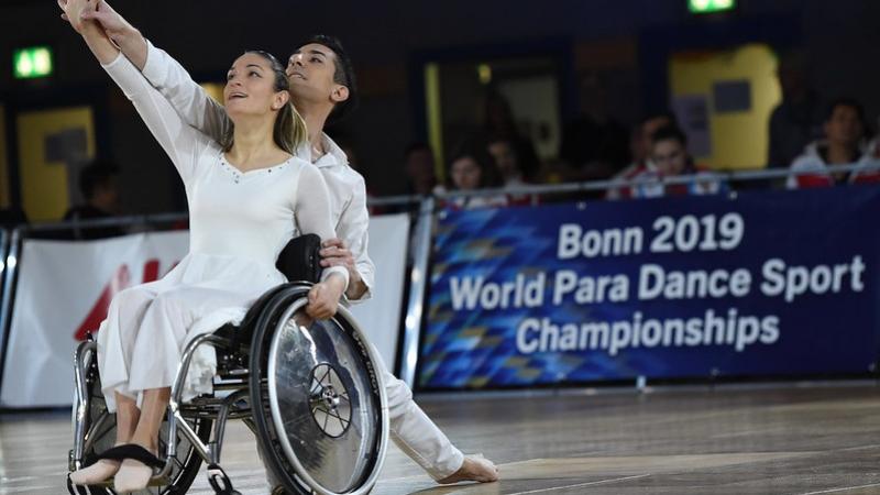 A woman in a wheelchair and a male partner in a dance competition
