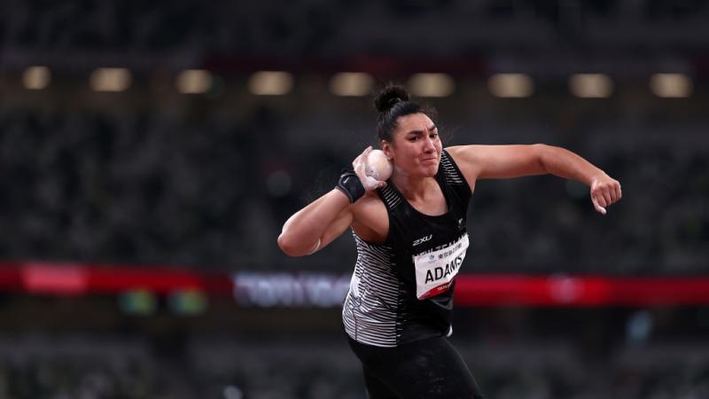 A female athlete competing in shot put