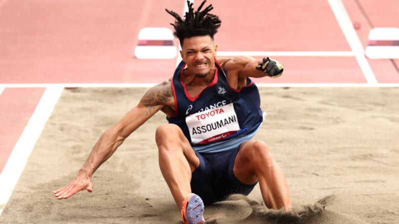 A male long jumper lands his jump at the Tokyo 2020 Paralympic Games.