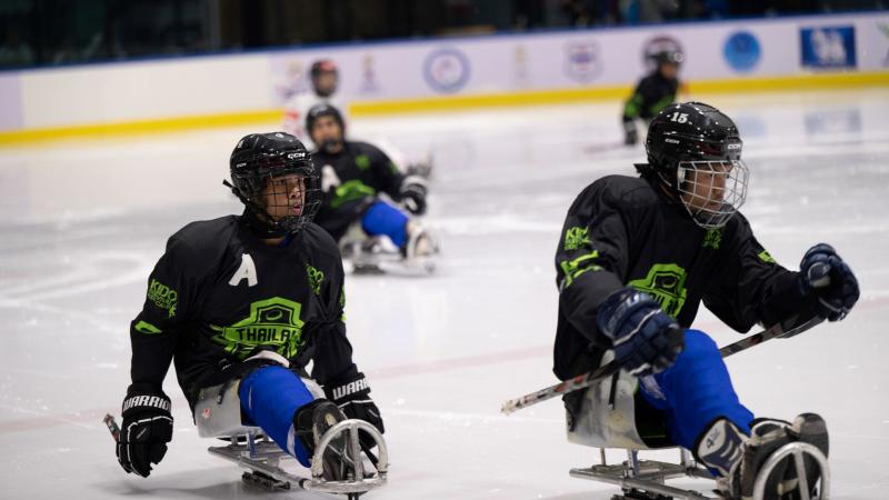 Three Thai Para ice hockey players in a game on ice