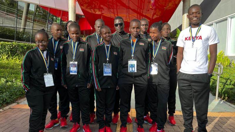 a group of Kenyan Goalball players smiling with their coach 