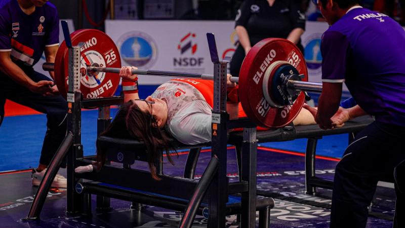 A woman on a bench press in Para powerlifting competition