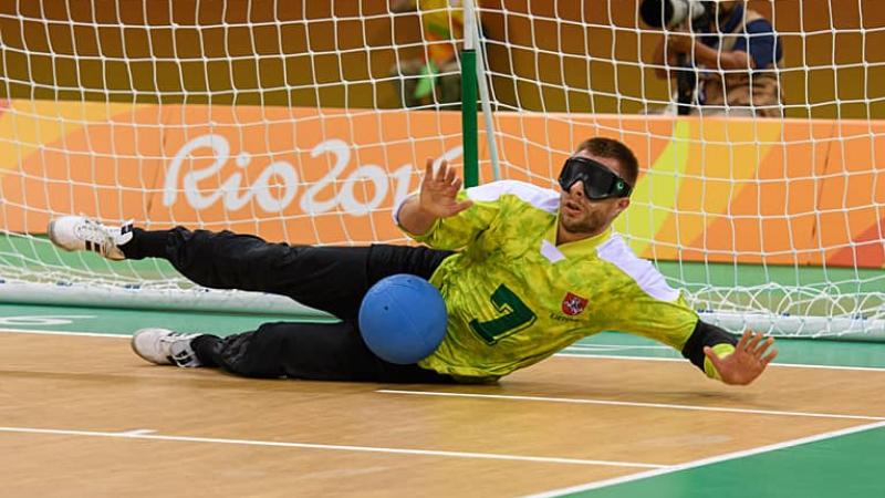 Goalball player Genrik Pavliukianec blocks a shot on the floor