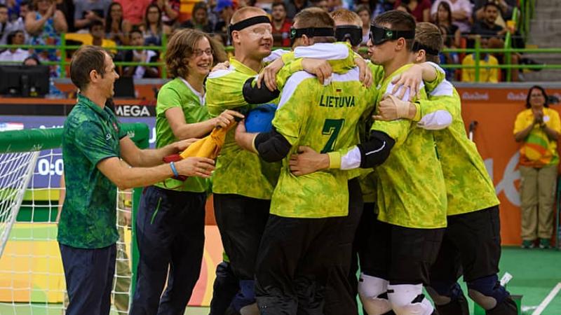 A group of Lithuanian goalball players hugging in celebration 