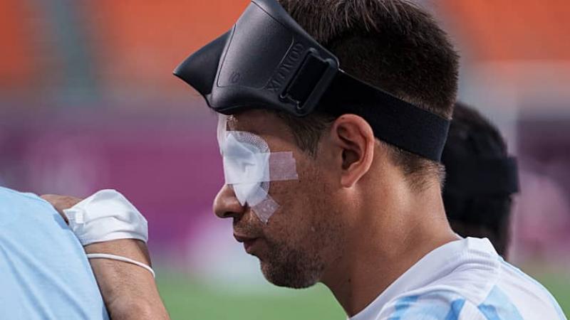 a blind footballer with his eyes taped and a blindfold on his forehead