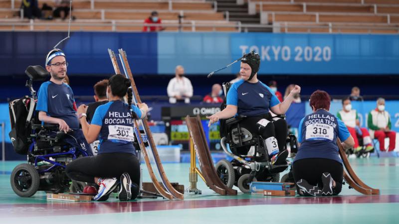 Two boccia athletes are competing in a match at Tokyo 2020 with their sport assistants.