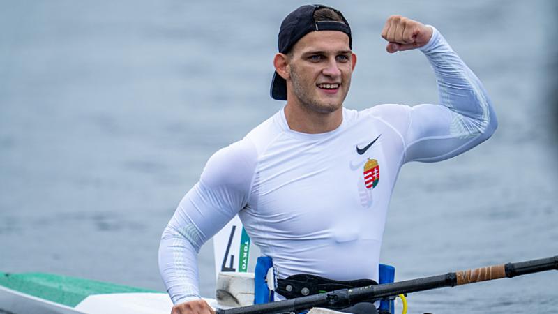 Male Para canoeist Peter Pal Kiss flexes his bicep in celebration 