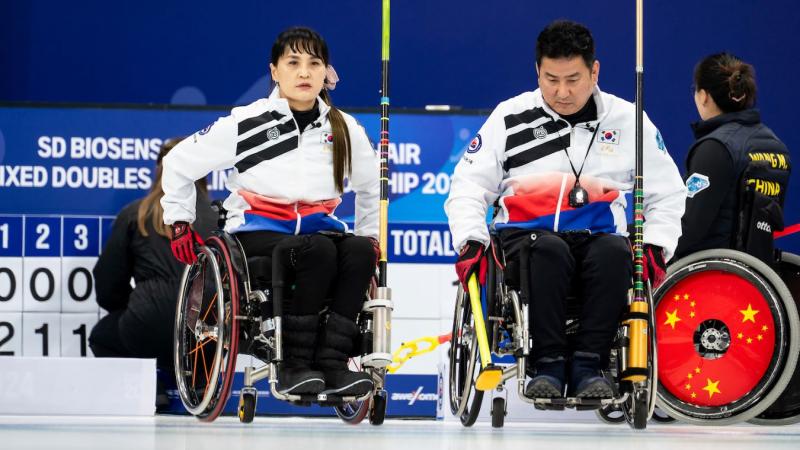 A male and a female wheelchair curlers take part in a competition