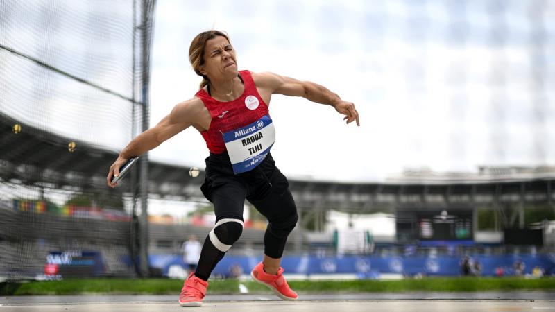 A short stature woman competing in the discus throw