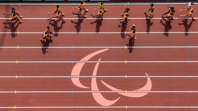 Overhead photo of athletes and their guides running on the track.