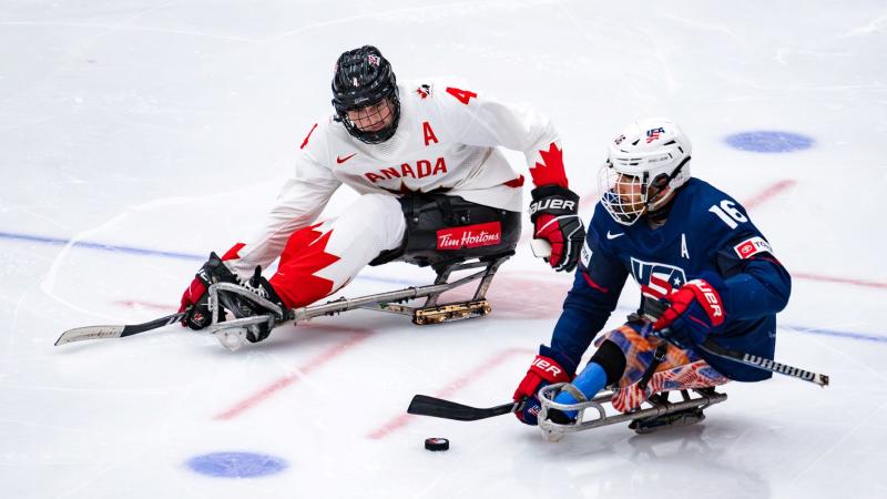 A Para ice hockey player from USA against a player from Canada