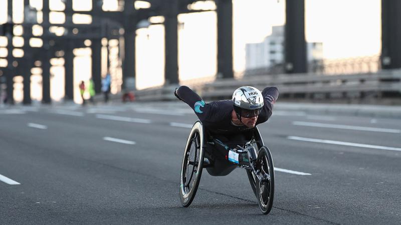 A male wheelchair racer crossing a bridge