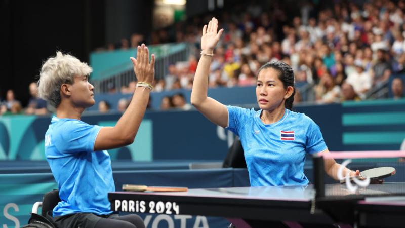 A mixed doubles Para table tennis players from Thailand do a high-five