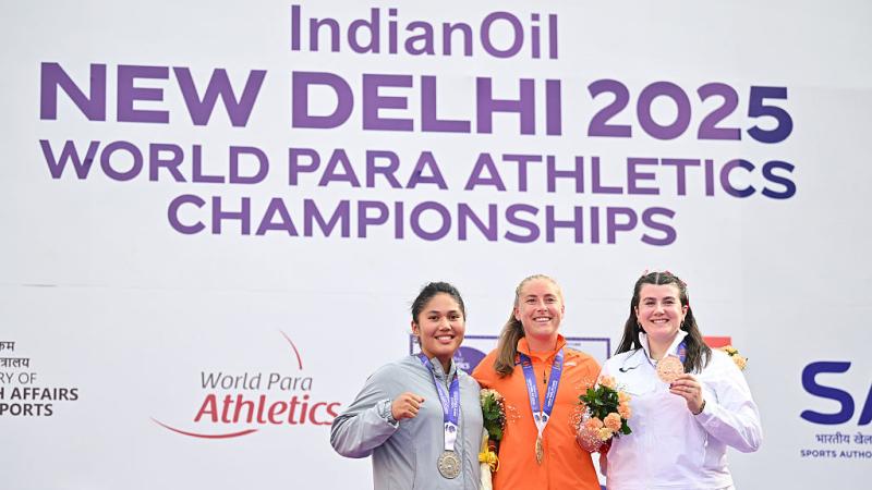 Three women showing their medals after a competition