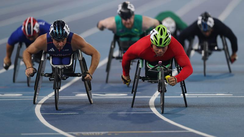 Six male wheelchair racers in a competition