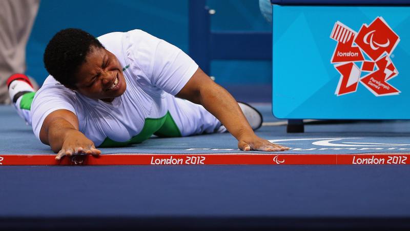 Loveline Obiji of Nigeria celebrates on the floor in the Women's -52 kg Powerlifting event.